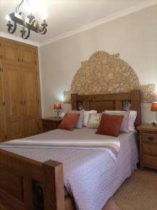 Schlafzimmer mit einem großen Bett mit einem Kopfteil aus Stein in der Unterkunft Vila da Mesa in Algoz