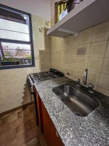 a kitchen with a sink and a stove at Il nono in San Fernando del Valle de Catamarca