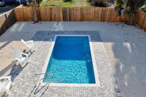 a small swimming pool with two chairs and a fence at Casa Linda by Pristine Properties Vacation Rentals in Mexico Beach