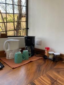 Ocotal的住宿－Guesthouse Casa Avi Fauna，咖啡壶和杯子,坐在木地板上