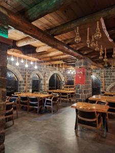 un ristorante con tavoli e sedie in legno e pareti in mattoni di Hemşin Ata Konağım a Çamlıhemşin