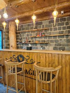a restaurant with a bar with two chairs and a table at Hemşin Ata Konağım in Çamlıhemşin