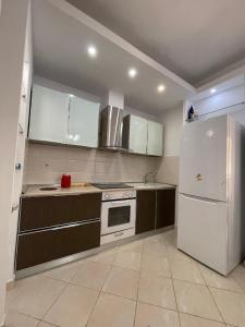 ヴロラにあるPerla Marina Houseのキッチン(白い家電製品、白い冷蔵庫付)