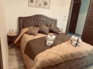 a bedroom with a large bed with towels on it at La Corte del Moro in Pachino