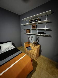 a bedroom with a bed and a table and shelves at Il nono in San Fernando del Valle de Catamarca