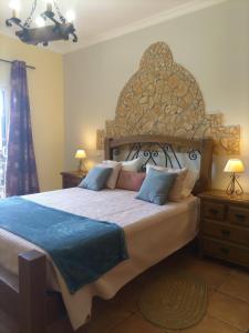 ein Schlafzimmer mit einem großen Bett mit einem großen Kopfteil in der Unterkunft Vila da Mesa in Algoz