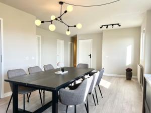 a dining room with a black table and chairs at The Greyhouse "Big Apartment" in Höfn +14 photos