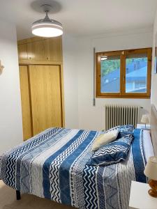 畢斯卡斯的住宿－Apartamento Espert Biescas，一间卧室配有一张带蓝白色毯子的床