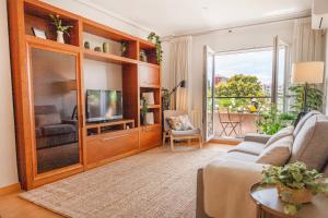 een woonkamer met een bank en een tv bij Luxotica Gardens Valencia in Valencia
