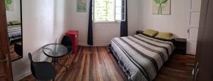 1 dormitorio con cama, escritorio y ventana en Hostal Po, en Valparaíso