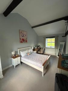 a bedroom with a large bed and a window at Swallow Cottage in Ripon