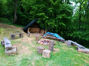 a cabin with a pile of logs and a tent at Bieszczadzkie Dworki Ropienka Dolna in Ustrzyki Dolne