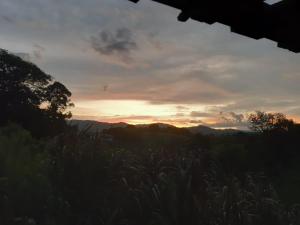 a view of the sunset from a field of grass at Hotel del Campo in Quimbaya