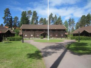 un grande edificio in legno con un sentiero di fronte ad esso di Rättviksgårdens Vandrarhem a Rättvik