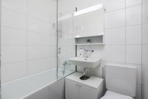 a white bathroom with a toilet and a sink at Downtown Deluxe Studio with Queen Bed BE-26 in Zürich +9 photos