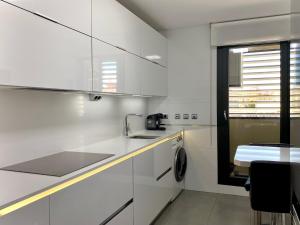 una cucina bianca con lavello e fornello di Torre Luxor a León