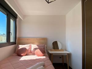 una camera da letto con un letto con cuscini rosa e una finestra di Torre Luxor a León Altre 44 foto