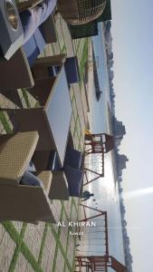 阿錫蘭的住宿－منتجع اووه يامال البحري في الخيران OOh Yaa Mal，享有带桌椅的建筑的顶部景色