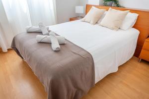 een slaapkamer met een bed met handdoeken erop bij Luxotica Gardens Valencia in Valencia