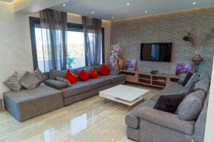 uma sala de estar com dois sofás e uma televisão em Luxury 3 bedroom panoramic views in Hotspot with Fibre Optic Wifi and Netflix em Tânger