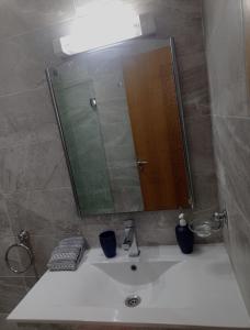 ein Badezimmer mit einem Waschbecken und einem großen Spiegel in der Unterkunft Appartement proche de toutes les commodités, RESIDENCE MARWA in Oulad Yakoub