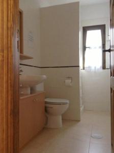 a bathroom with a toilet and a sink and a window at Casa Carlotta Lajares in Lajares