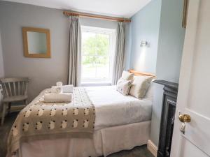 een slaapkamer met een bed en een raam bij The Smithy in Borrowdale Valley