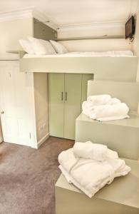 two bunk beds in a room with white towels at Chic & bright flat near Holyrood Park in Edinburgh