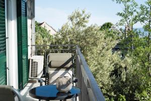 a balcony with a table and chairs and trees at House Villa Danica on the hills in Srinjine