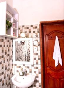 een badkamer met een wastafel en een spiegel bij Little Birds Paradise in Ruhengeri