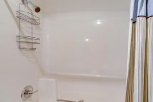 a bathroom with a shower with a shower curtain at Pet-Friendly Oak Harbor Condo Walk to Lake! in Sand Beach +24 photos