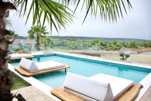 a swimming pool with two chaise lounge chairs and a resort at SANIMAR By Mono Alex in Kassandra