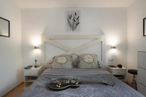 een gitaar die op een bed in een slaapkamer ligt bij Private Chalet - Fast Wi-Fi - Pool in Corralejo +17 foto's