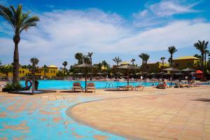 een zwembad op een resort met stoelen en palmbomen bij Private Chalet - Fast Wi-Fi - Pool in Corralejo