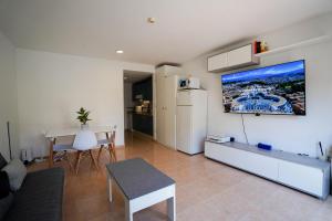 een woonkamer met een witte koelkast en een tafel bij Private Chalet - Fast Wi-Fi - Pool in Corralejo