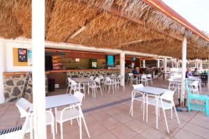 een restaurant met tafels en stoelen op het strand bij Private Chalet - Fast Wi-Fi - Pool in Corralejo