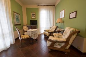 a living room with chairs and a table and a television at Locanda Miranda in Tellaro +37 photos