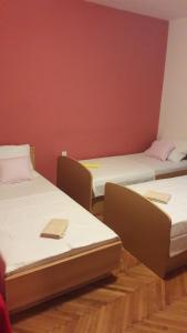 3 camas en una habitación con una pared roja en Apartments Nena, en Split