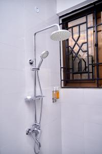 - Baño con cabezal de ducha junto a una ventana en Diamond Apartments, en Arusha