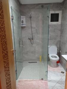 ein Bad mit einer Glasdusche und einem WC in der Unterkunft Appartement proche de toutes les commodités, RESIDENCE MARWA in Oulad Yakoub