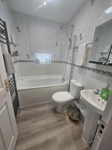 a bathroom with a tub and a toilet and a sink at St Albans City Stays - Near Luton Airport - St Albans Abbey & City Train station - Close to London- Harry Potter World - The Odyssey Cinema - Abbey Cathedral- Contractors I Business I Leisure- sleeps upto 6 people in Saint Albans +19 photos