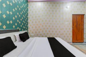 1 dormitorio con 1 cama y puerta de madera en OYO C.M Paradise, en Lucknow