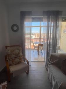 a bedroom with a couch and a chair and a table at Lo Pagan Beachfront Aircon Apartment in San Pedro del Pinatar