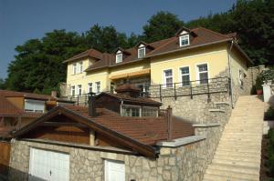a large yellow house with a brown roof at Alabárdos Panzió és Apartmanház in Esztergom