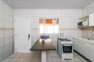 帕羅卡的住宿－Rental Palhoça- Acomodações Residenciais IV，厨房配有台面和炉灶。