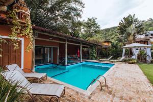 a swimming pool in the backyard of a house at Pousada Terra Madre in Ilhabela