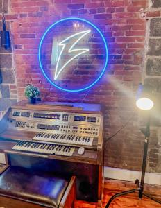 a neon sign on a brick wall with an electronic keyboard at Stylish Philly Loft in Philadelphia