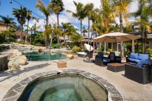 歐申賽德的住宿－Oasis with heated pool, mini golf, hot tub & barbq area，后院的游泳池配有椅子和遮阳伞