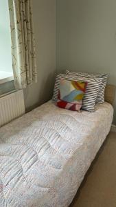 a bedroom with a bed with a pillow and a window at Swallow Cottage in Ripon