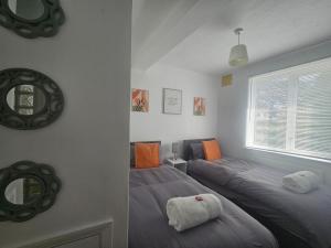 a bedroom with two twin beds and a mirror at St Albans City Stays - Near Luton Airport - St Albans Abbey & City Train station - Close to London- Harry Potter World - The Odyssey Cinema - Abbey Cathedral- Contractors I Business I Leisure- sleeps upto 6 people in Saint Albans